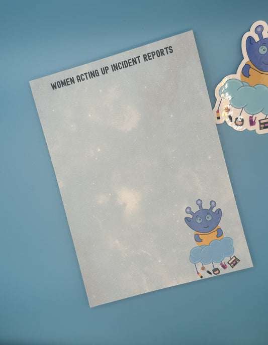 Notepad with character Cosmo Menace that looks like a blue alien floating on a cloud with makeup hanging from it. The notepad is a light blue sparkle background and has a heading on notepad that states "women acting up incident reports". The notepad is sitting on top of a blue background and a sticker.
