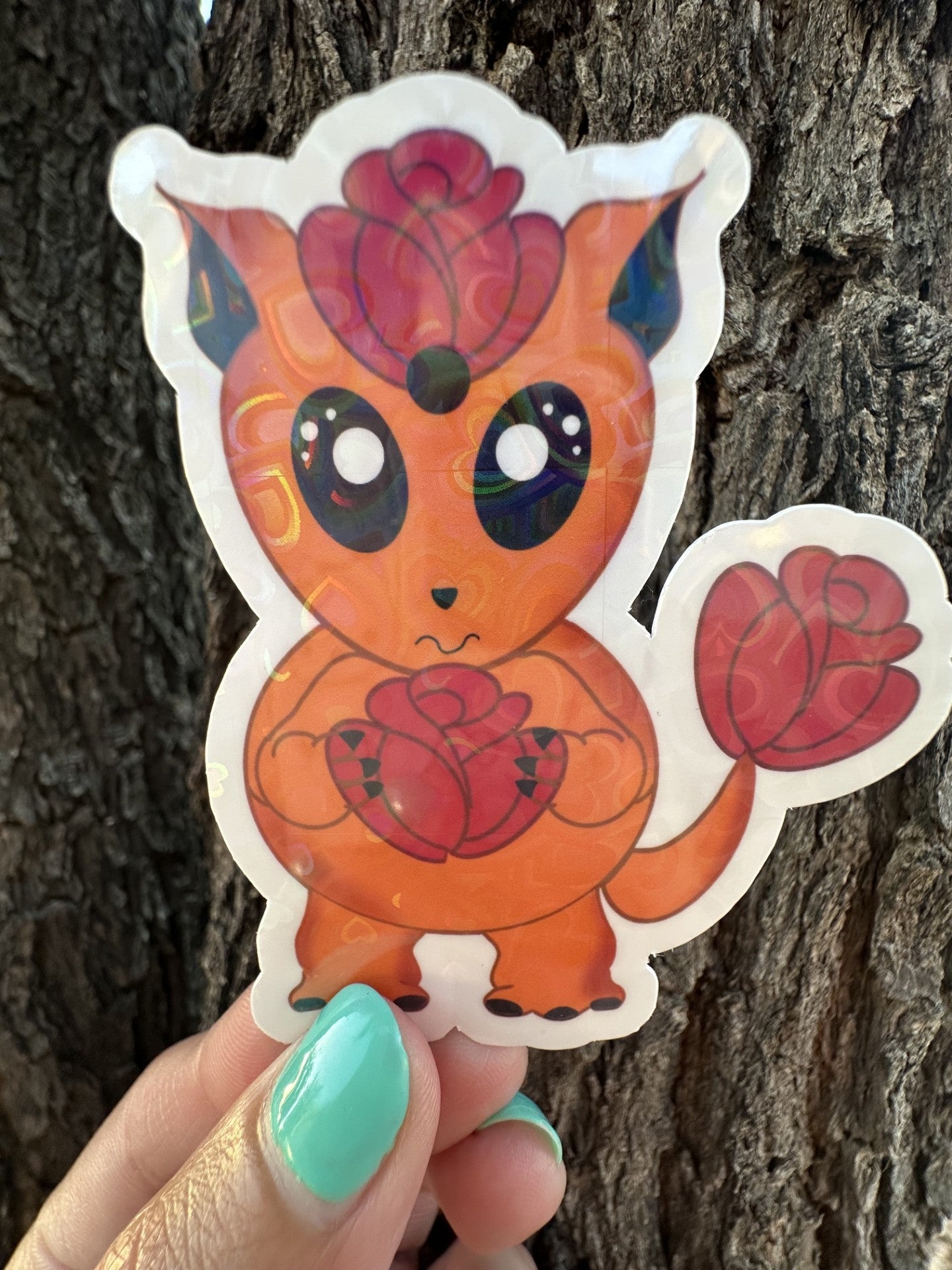 Orange cartoon sticker heart holographic character with red roses against a tree bark background. The character is holding a red rose and has a red rose on top of the head and has one on the tail.