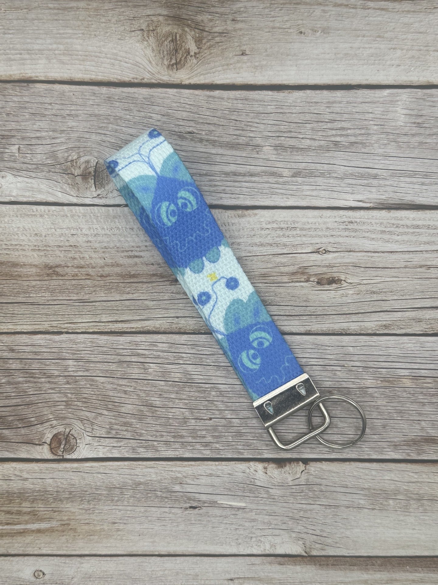 Blue unique character with turquoise eyes, and a little spark coming from it on a wooden surface.