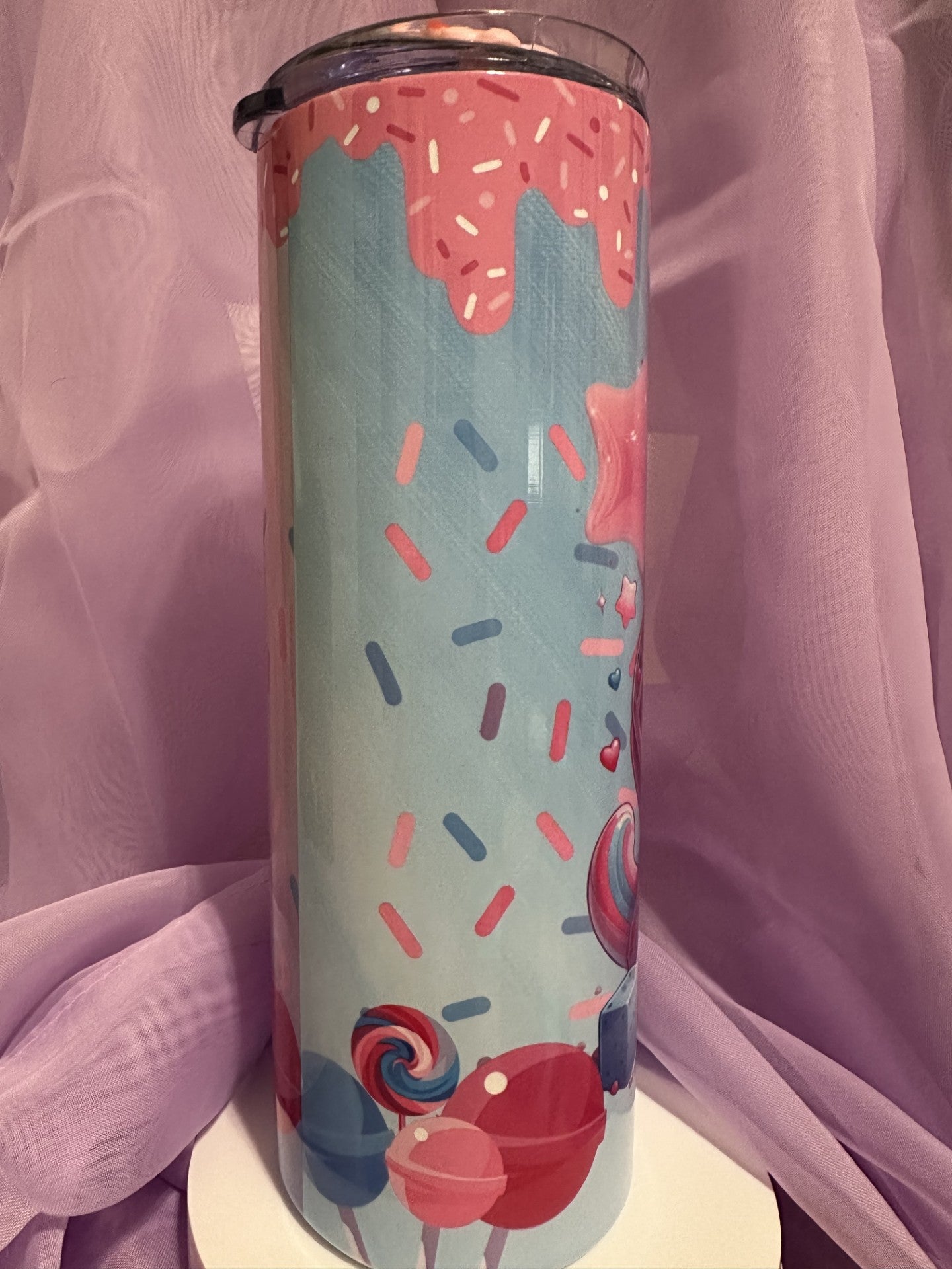 A tall, skinny tumbler decorated with an illustration of a heart-shaped waffle cone filled with blue and pink swirled ice cream, topped with a large red heart and sprinkles.
