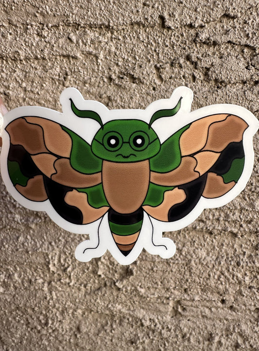 A fictional character sticker that has camouflage color that is an animal wasp shape and has black colored glasses. 