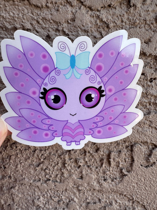 A vinyl sticker cartoon butterfly character with purple wings and a blue bow. The character has purple and black eyes with light purple circle patterns on the wings. The background is a textured brown background.