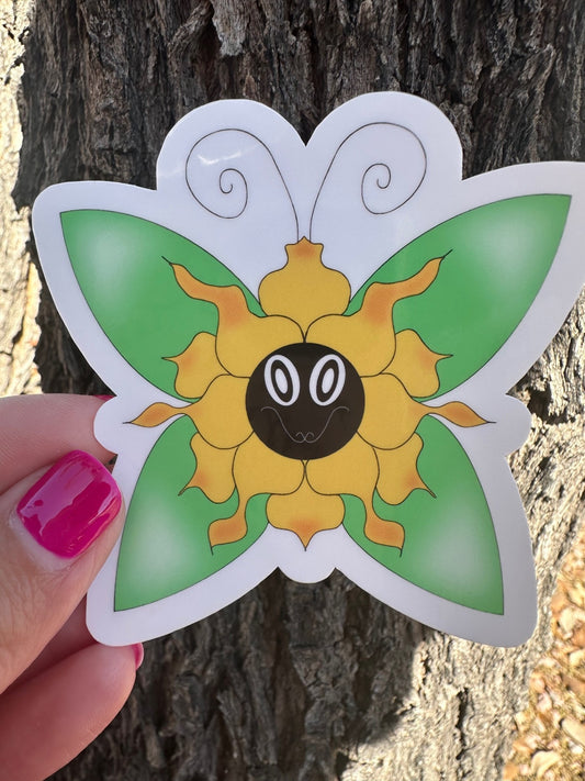 Hand-drawn whimsical flower character that is yellow with orange hues, with a face and a vibrant green butterfly perched on a rustic tree branch.