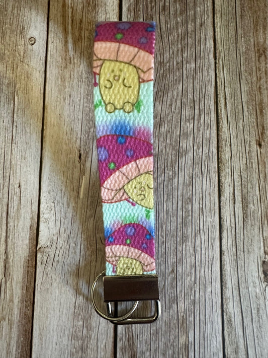 Wristlet with a neon-colored character mushroom on a wooden surface.