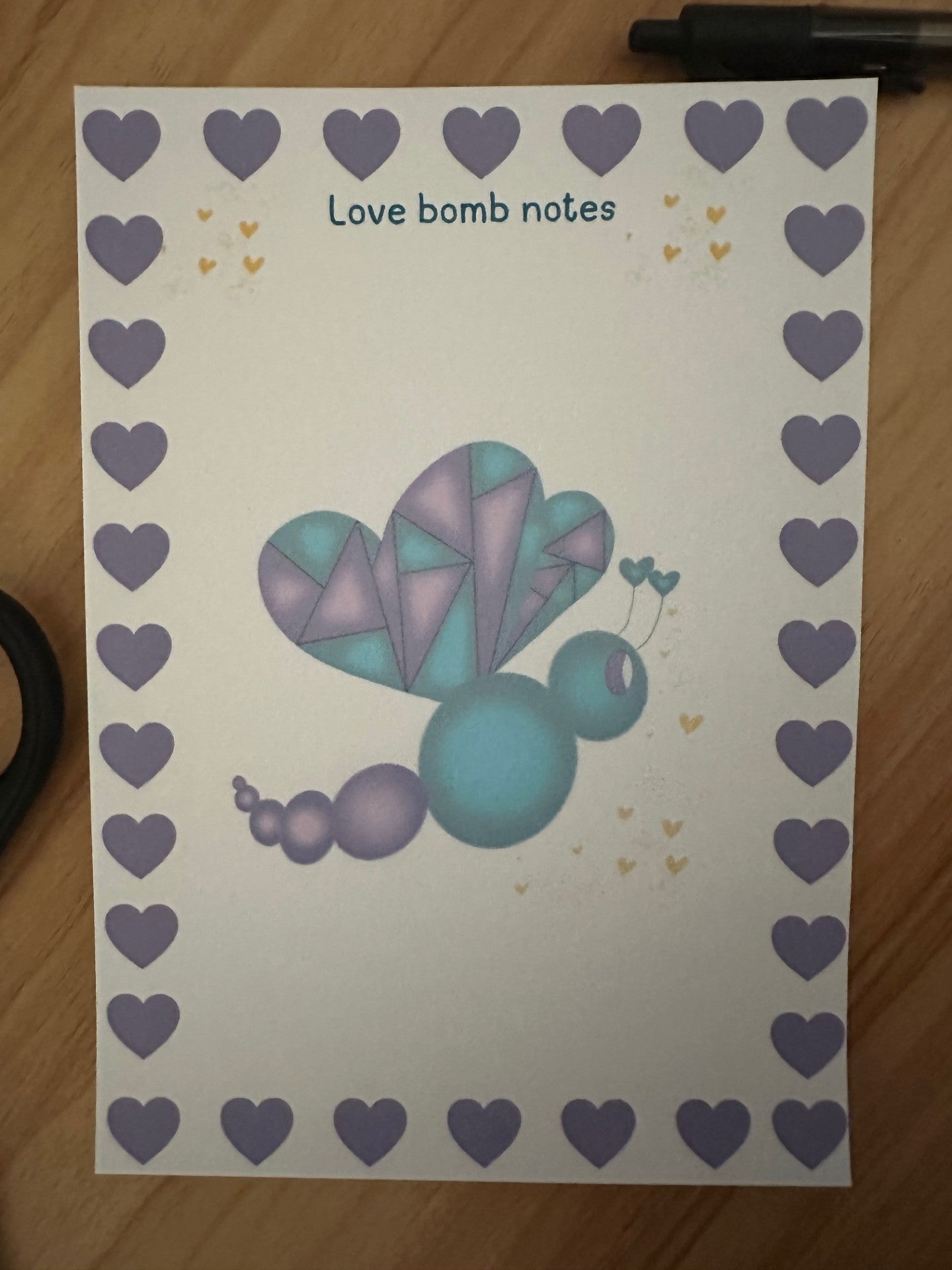 Notepad with fictional character love mist. Love mist has a purple and deep green color that has yellow hearts dropping from her. 