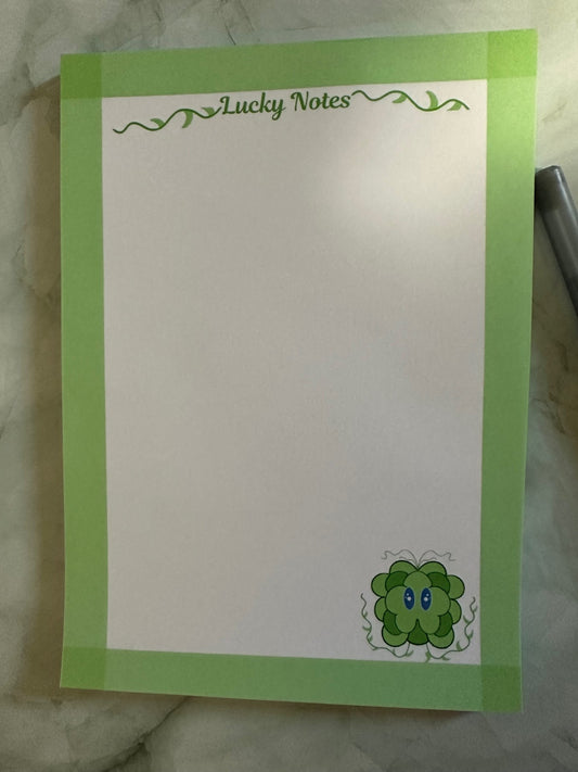 Note pad stating "lucky notes" on top. With fictional character lucky displayed on the bottom right. Lucky is a green and dark green color with his vines up.