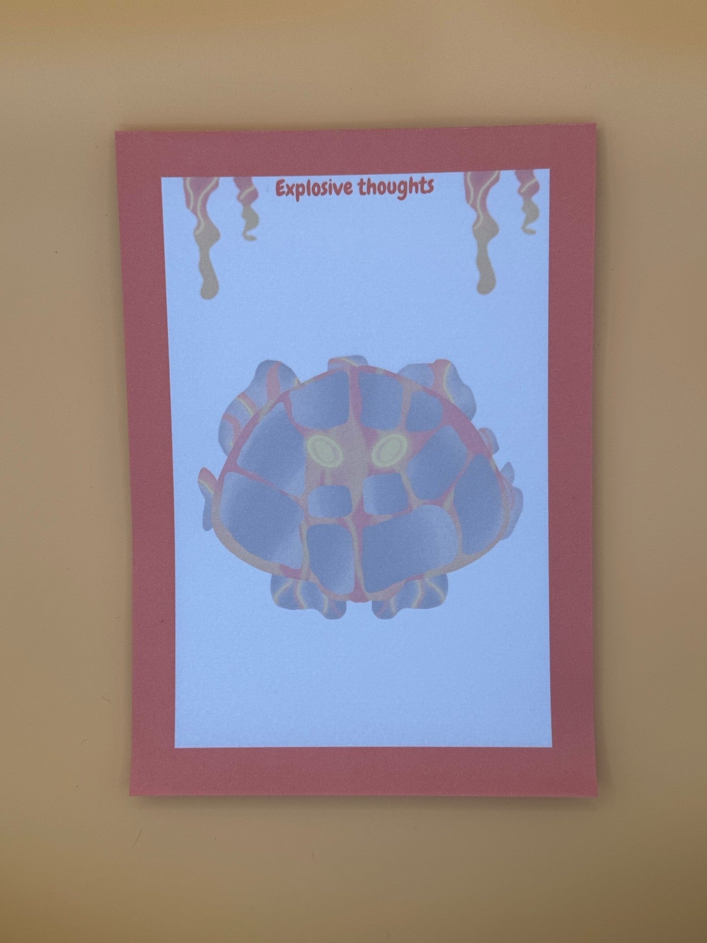 A notepad that has rocks and orange and red lava coming from it. The lava character has yellow eyes. The notepad has orange edges all around the four corners and has lava coming down from the top of the notepad. The notepad has a heading of " Explosive thoughts" The notepad is sitting on top of an orange background. 