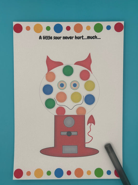 A notepad that has a red gumball machine character. Inside of the gumball machine is different color gumballs and coming out of the character is red horns and a red devil tail. The notepad has red, orange, green and blue dots on the top of the notepad and bottom. The heading of the notepad states "A little sour never hurt....much...". The notepad is sitting on top of a blue background with a pen.