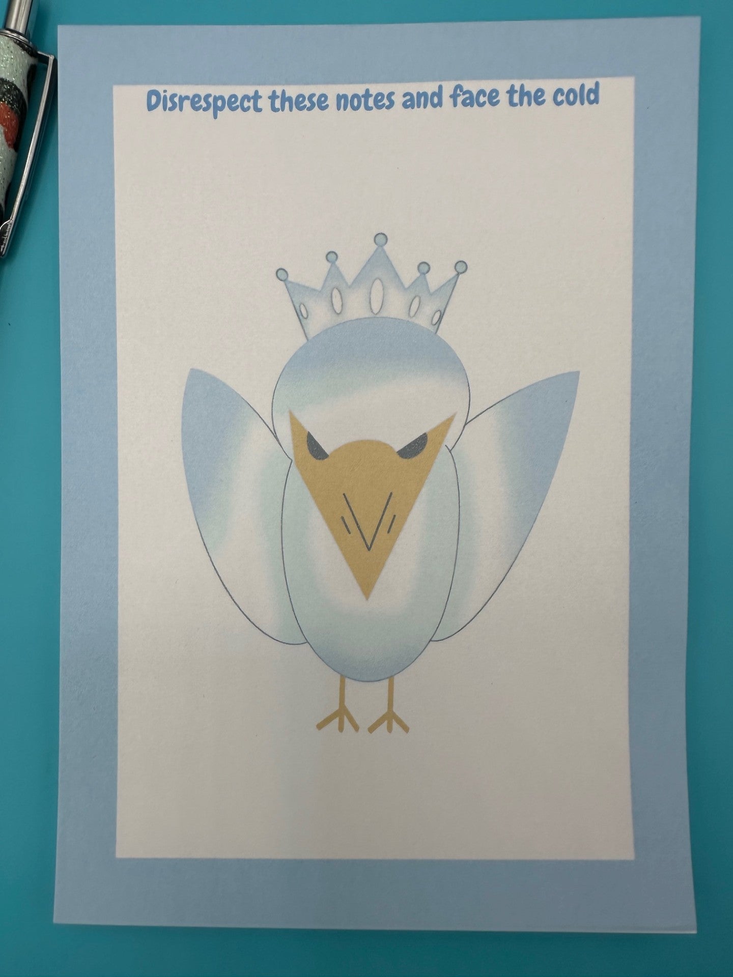A notepad that has a bird character on it that is blue and white color with a yellow snout and black eyes and also has a crown on top of its head. The notepad edges has a light blue color with the heading on top of the notepad stating "Disrespect these notes and face the cold". 