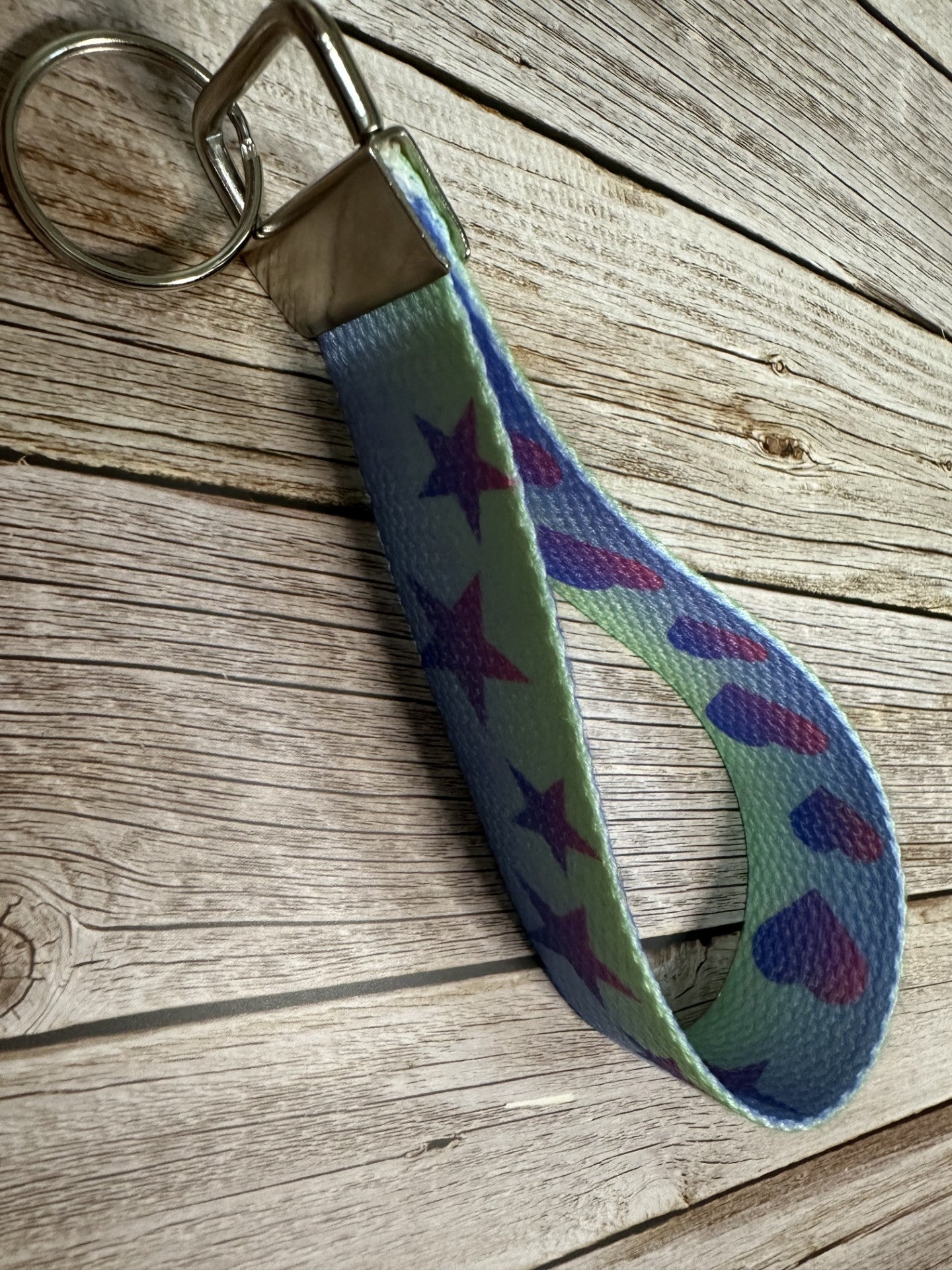 Keychain with star and heart pattern on a wooden surface.