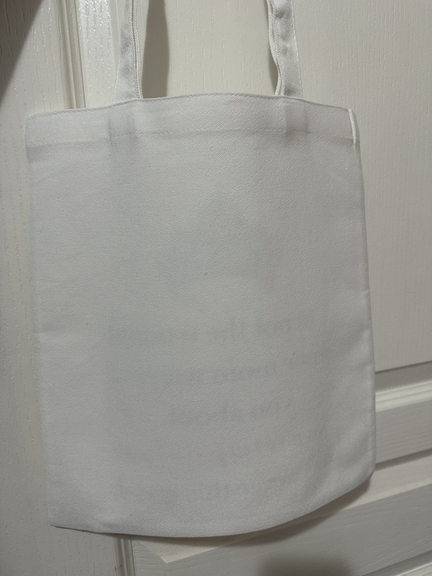 White tote bag on a white background. The back of tote bag.