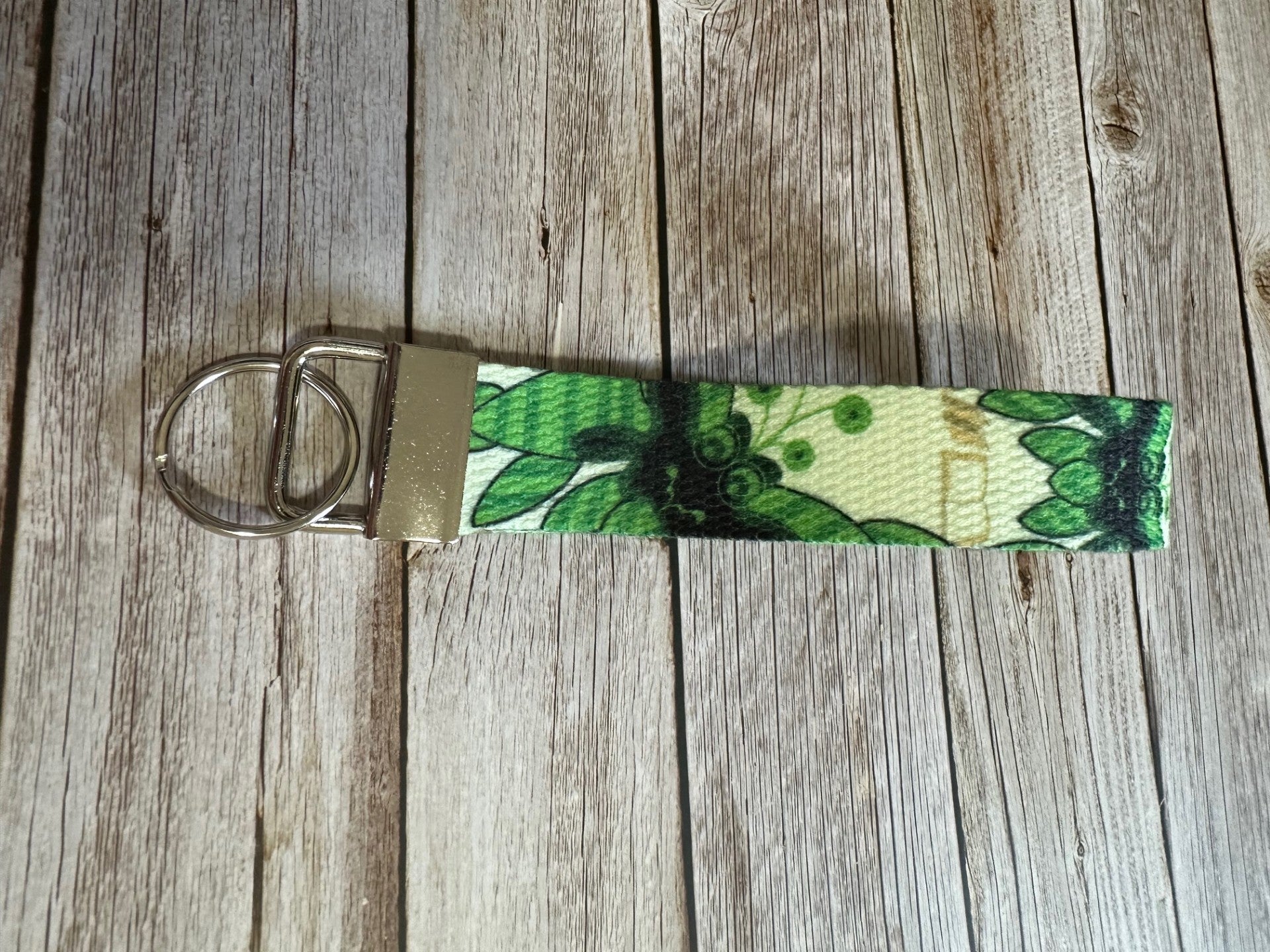 Keychain with a green fictional character pattern on a wooden surface.