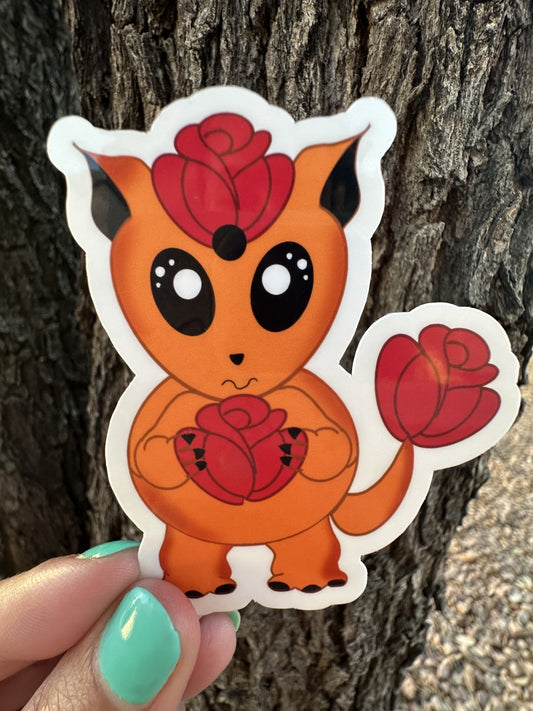 Orange cartoon sticker character with red roses against a tree bark background. The character is holding a red rose and has a red rose on top of the head and has one on the tail.