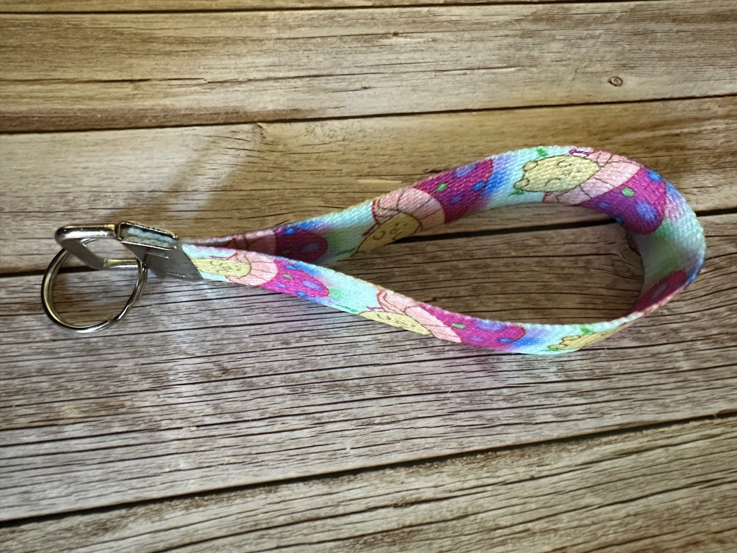 Wristlet with a neon-colored character mushroom on a wooden surface.