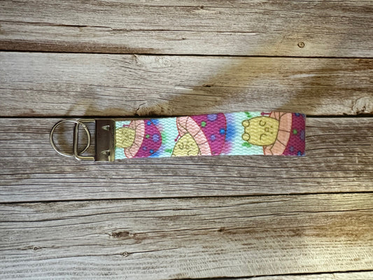Wristlet with a neon-colored character mushroom on a wooden surface.
