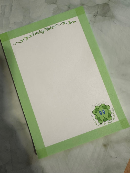 Note pad stating "lucky notes" on top. With fictional character lucky displayed on the bottom right. Lucky is a green and dark green color character with his vines up.