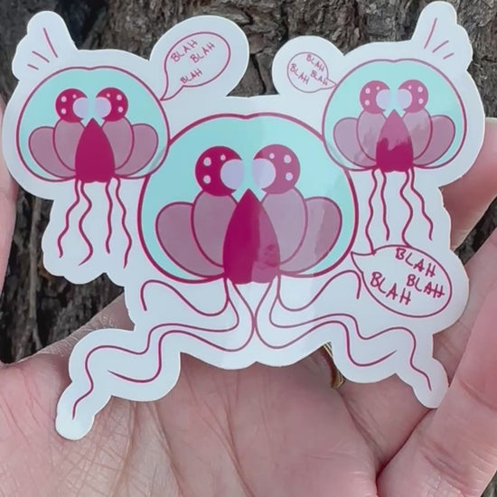 A sticker featuring three cartoon jellyfish-like creatures in teal and maroon colors with multiple speech bubbles that all say 'BLAH BLAH BLAH'.