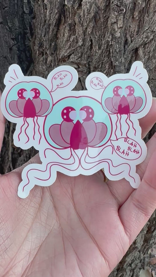 A sticker featuring three cartoon jellyfish-like creatures in teal and maroon colors with multiple speech bubbles that all say 'BLAH BLAH BLAH'.