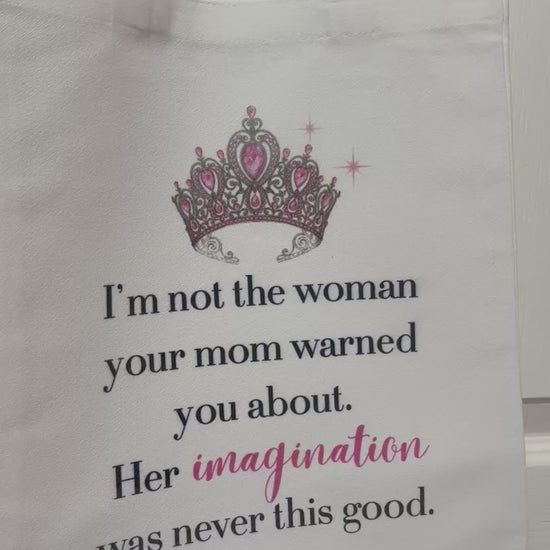 White tote bag featuring a pink and silver crown graphic and the quote: 'I'm not the woman your mom warned you about. Her imagination was never this good