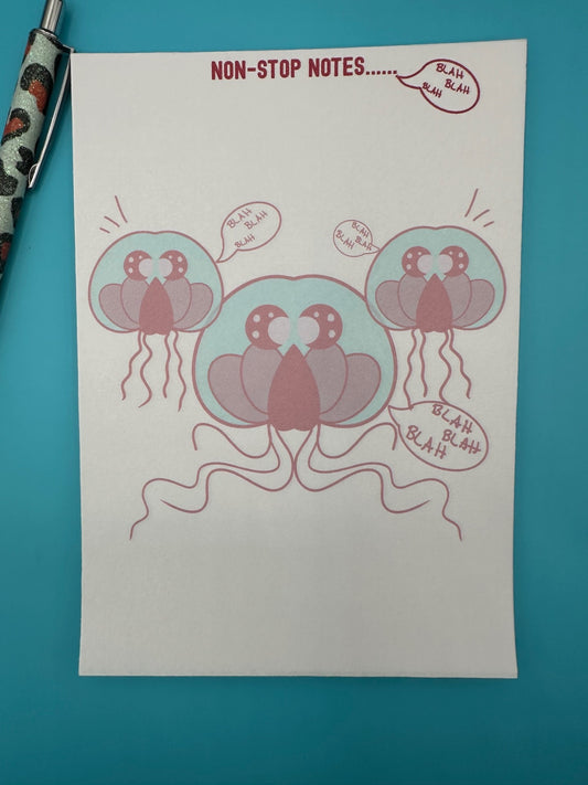 A notepad with three red jellyfish surrounded by the words "blah blah blah". The notepad heading has "non-stop notes.....". The notepad is sitting on a blue background with a pen.
