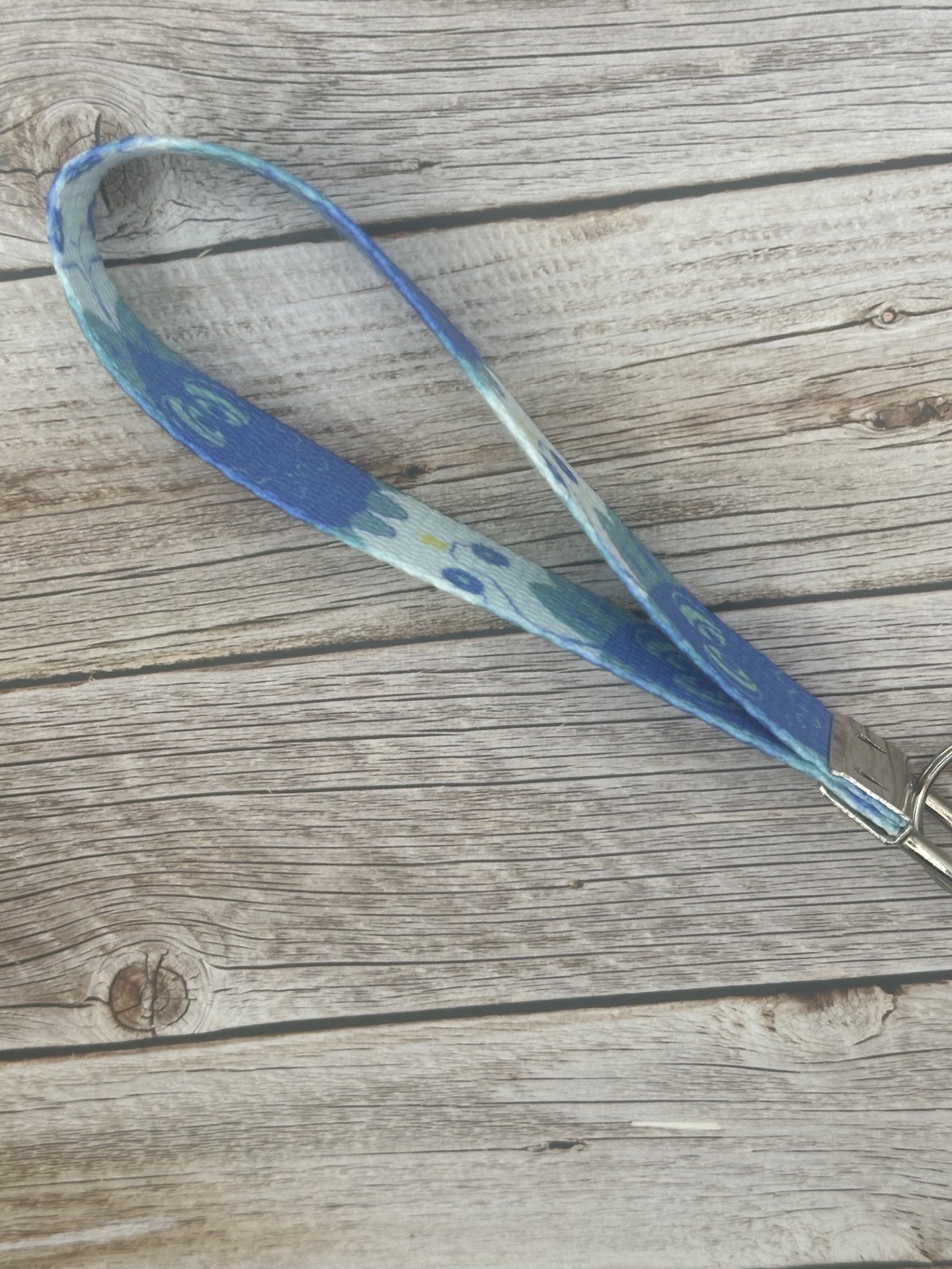 Blue unique character with turquoise eyes, and a little spark coming from it on a wooden surface side view. 